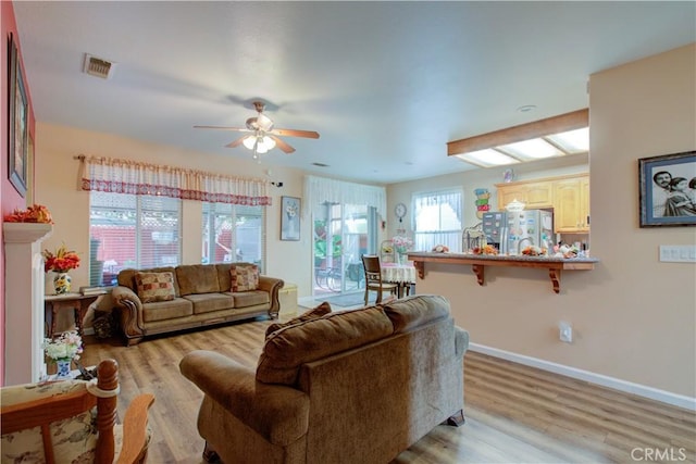 living room featuring ceiling fan and light hardwood / wood-style floors