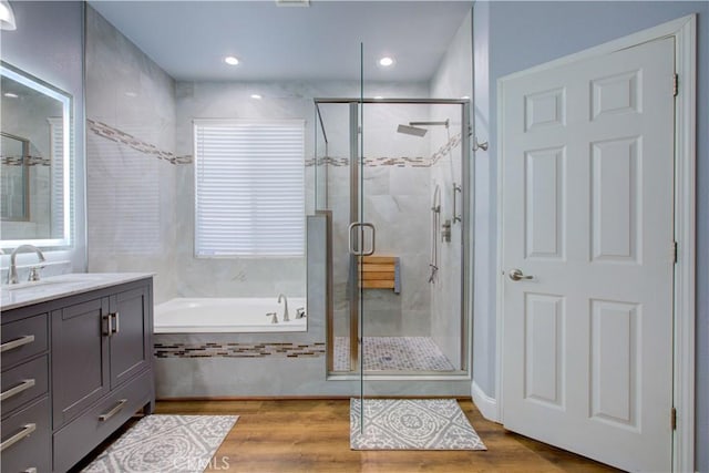 bathroom featuring vanity, hardwood / wood-style floors, and shower with separate bathtub