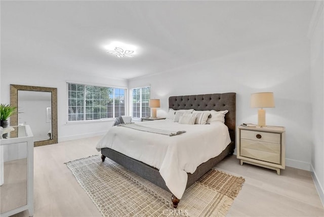 bedroom with light hardwood / wood-style floors and ornamental molding