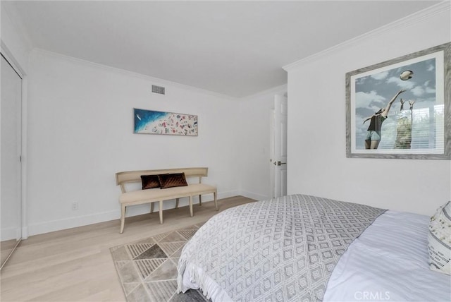 bedroom featuring crown molding and light hardwood / wood-style flooring