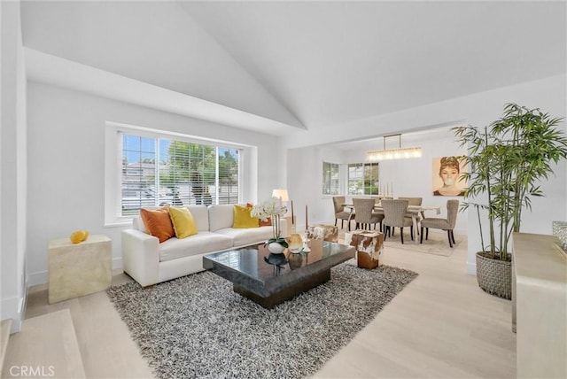 living room with hardwood / wood-style floors, high vaulted ceiling, and an inviting chandelier