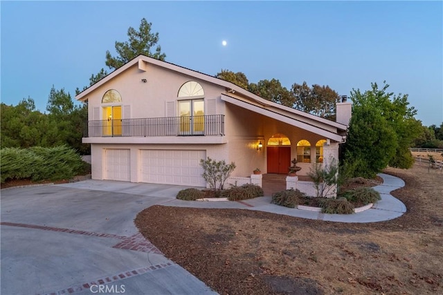 view of front property featuring a garage and a balcony