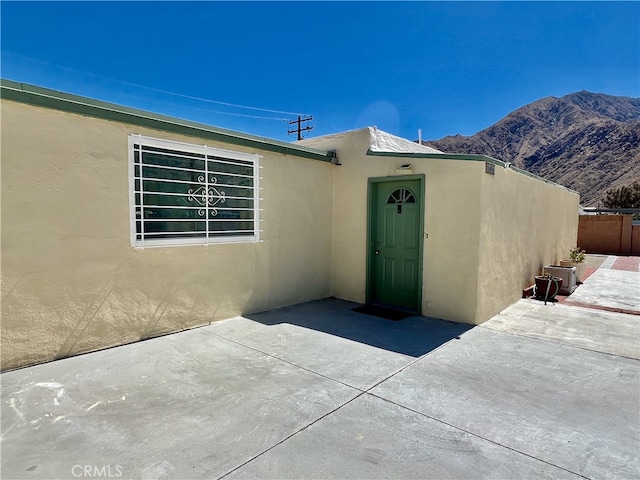 entrance to property featuring a mountain view and a patio area