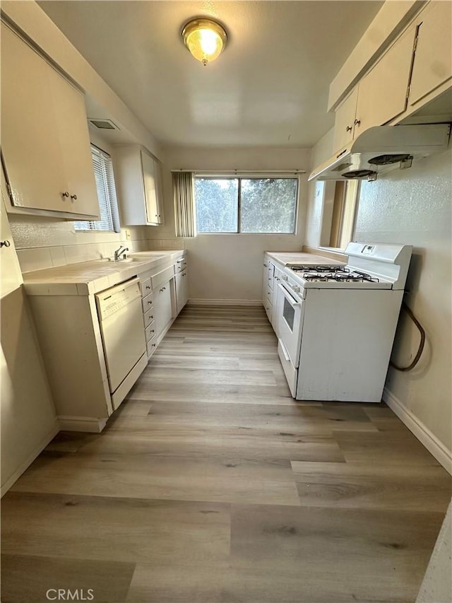 kitchen with light wood-type flooring, white cabinets, and white appliances