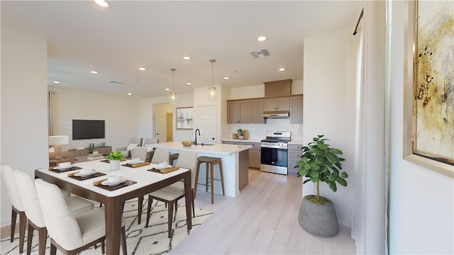 dining area with light wood-type flooring and sink