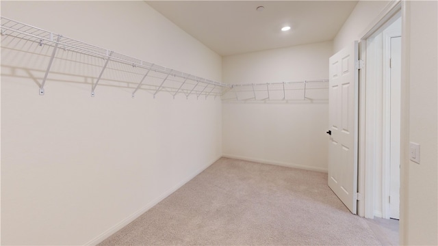 spacious closet featuring light colored carpet