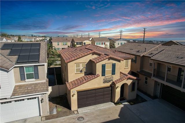 view of front of home with a garage, a balcony, and solar panels