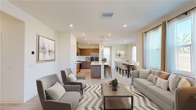 living room with light hardwood / wood-style floors and sink