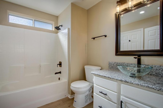 full bathroom with vanity, hardwood / wood-style flooring, toilet, and shower / washtub combination