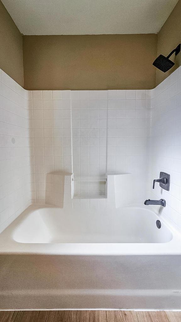 bathroom with shower / tub combination and hardwood / wood-style flooring