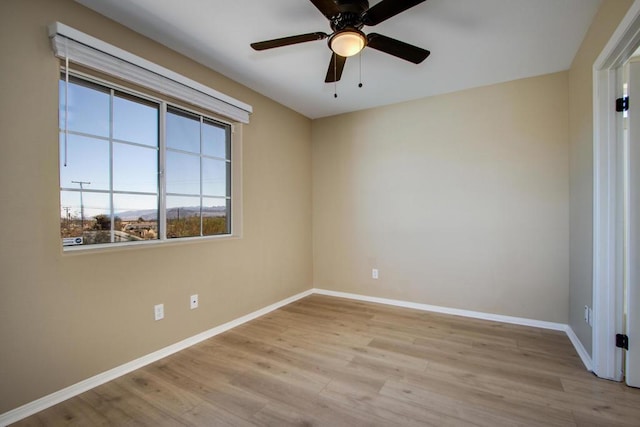 empty room with ceiling fan and light hardwood / wood-style flooring