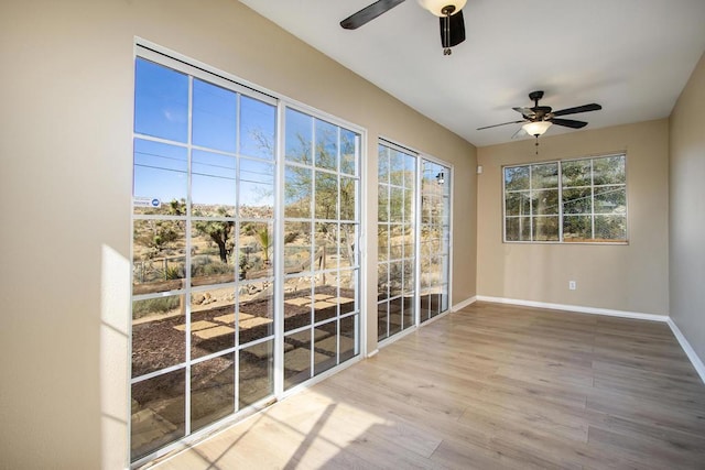 unfurnished sunroom featuring ceiling fan