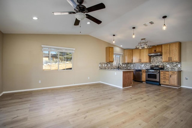 kitchen with light wood-type flooring, kitchen peninsula, hanging light fixtures, and appliances with stainless steel finishes