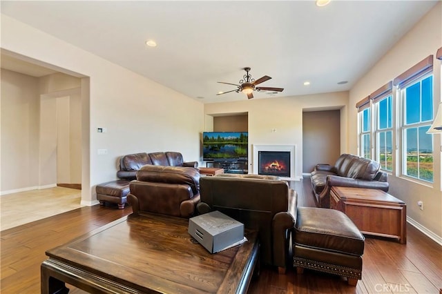 living room with dark wood-type flooring and ceiling fan