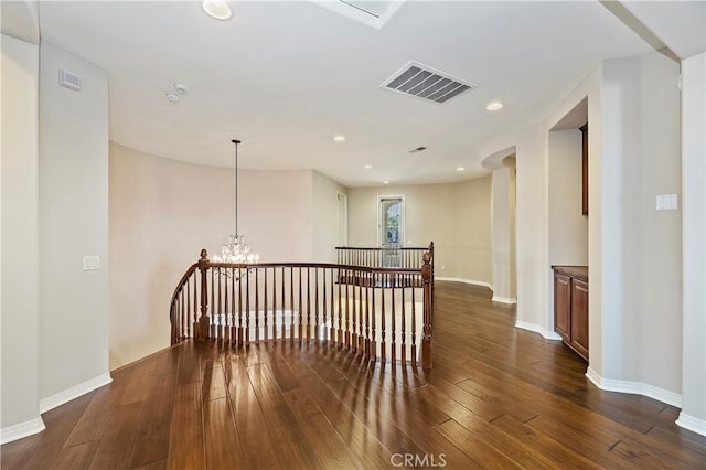 unfurnished room with dark hardwood / wood-style floors and a chandelier