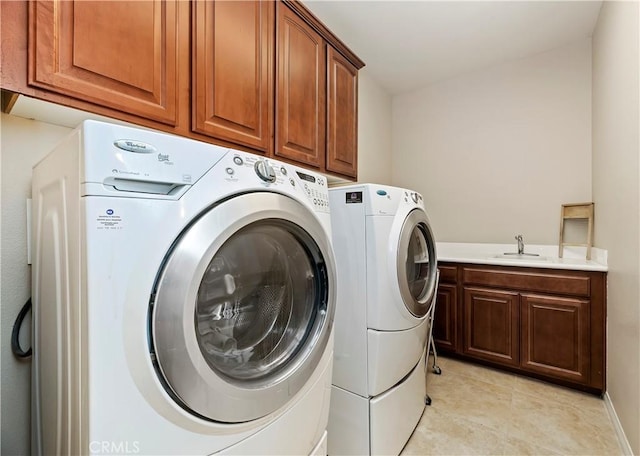 laundry area featuring independent washer and dryer, sink, cabinets, and light tile patterned flooring