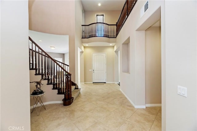 entryway with a high ceiling and light tile patterned floors