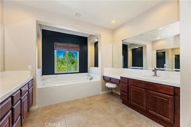 bathroom featuring vanity, tiled bath, and tile patterned floors