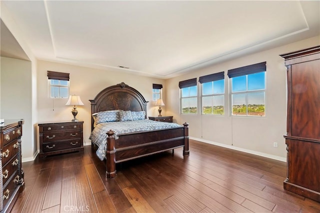 bedroom with dark hardwood / wood-style flooring and multiple windows