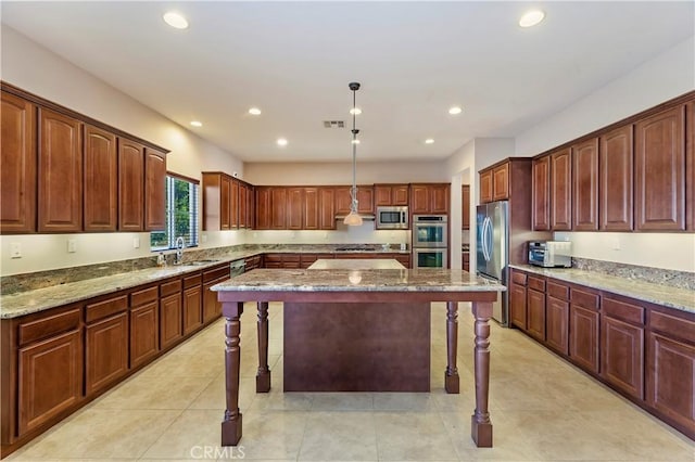 kitchen featuring sink, a kitchen breakfast bar, hanging light fixtures, a center island, and stainless steel appliances