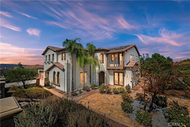 mediterranean / spanish home with a balcony and solar panels