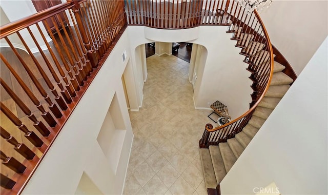 stairway featuring a towering ceiling