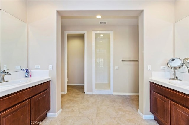 bathroom featuring tile patterned flooring, vanity, a shower, and toilet