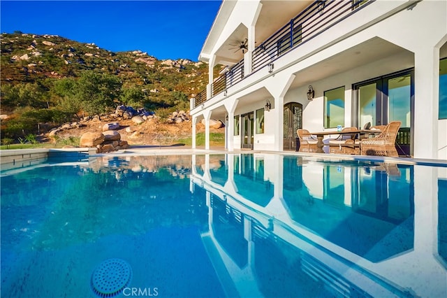 view of pool with a patio and ceiling fan