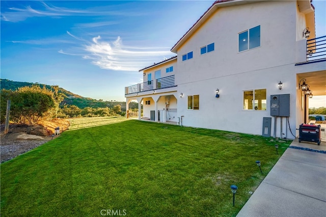 rear view of house featuring a yard and a mountain view