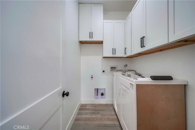 laundry room featuring electric dryer hookup, washer hookup, gas dryer hookup, light wood-type flooring, and cabinets