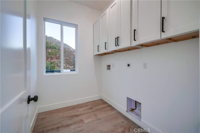 laundry room with cabinets, a mountain view, electric dryer hookup, washer hookup, and light hardwood / wood-style flooring