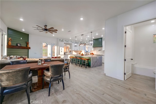 dining space with light hardwood / wood-style floors, sink, and ceiling fan