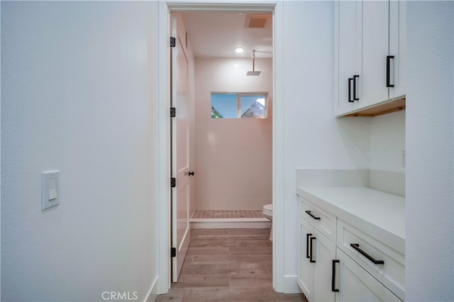 bathroom with toilet, walk in shower, hardwood / wood-style flooring, and vanity