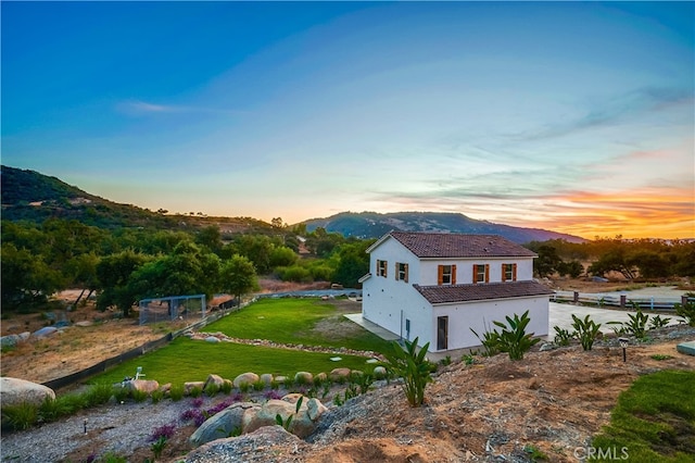 property exterior at dusk with a mountain view