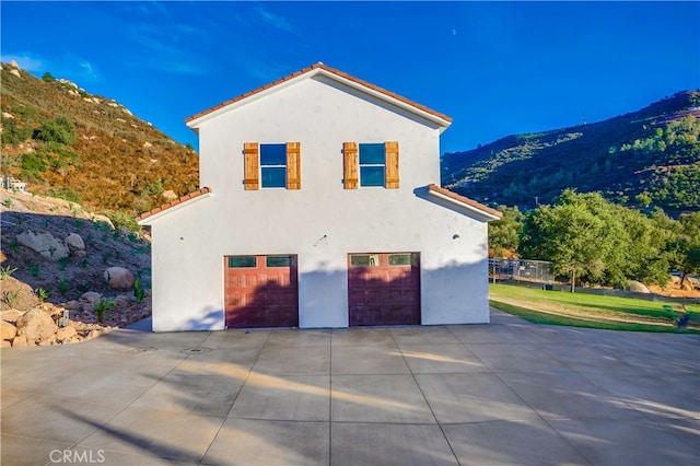 view of side of property featuring a garage and a mountain view