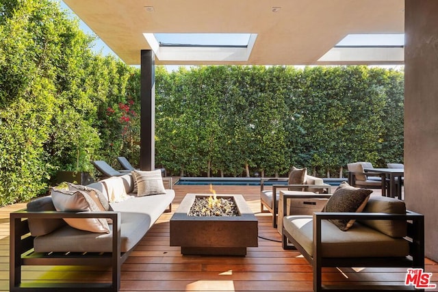 view of patio / terrace featuring a wooden deck and an outdoor living space with a fire pit