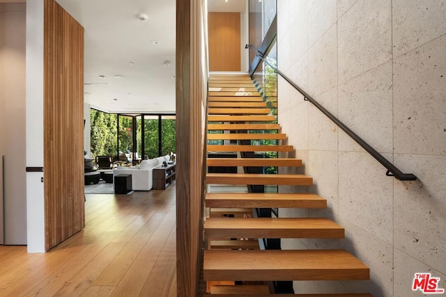 stairway with hardwood / wood-style flooring and floor to ceiling windows