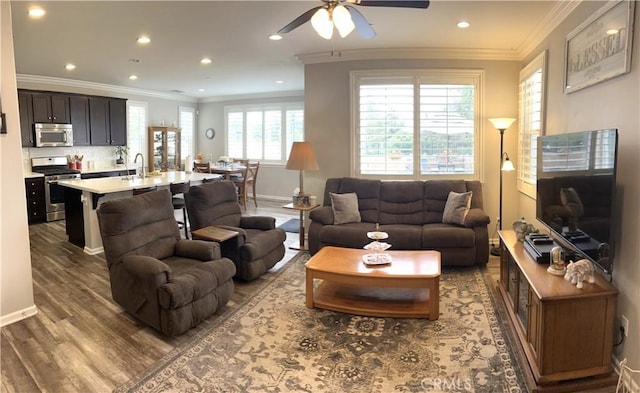 living room featuring ceiling fan, wood-type flooring, and ornamental molding