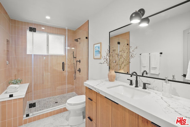 bathroom with vanity, toilet, and a shower with door