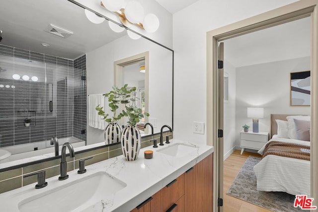 bathroom featuring vanity, an enclosed shower, and hardwood / wood-style flooring