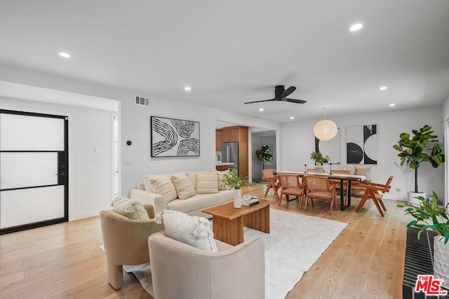 living room featuring ceiling fan and light hardwood / wood-style flooring