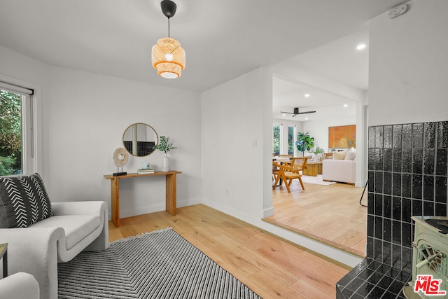 sitting room with ceiling fan and hardwood / wood-style flooring