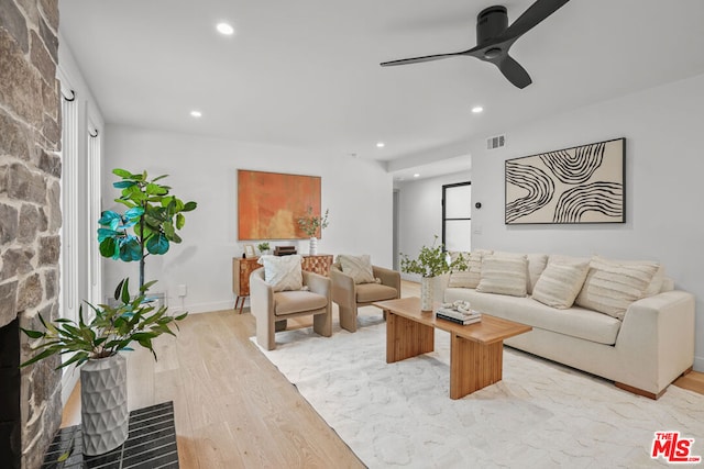 living room featuring light hardwood / wood-style flooring and ceiling fan