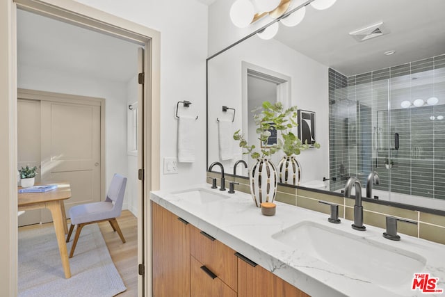 bathroom featuring hardwood / wood-style flooring, vanity, and an enclosed shower