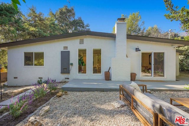 back of house featuring outdoor lounge area and a patio