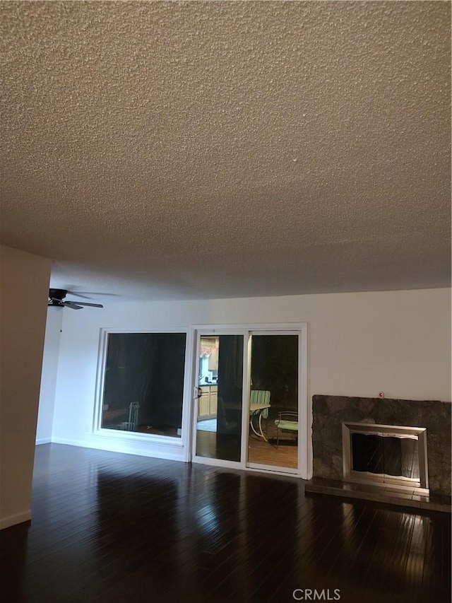 unfurnished room with hardwood / wood-style flooring, ceiling fan, and a textured ceiling