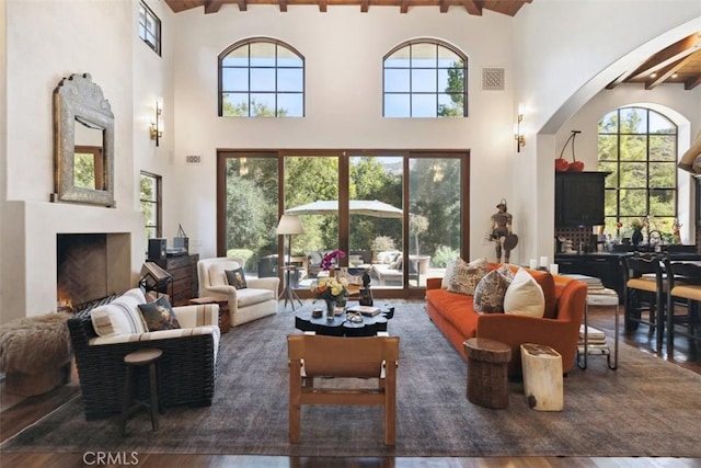 living room with beamed ceiling, dark hardwood / wood-style floors, and high vaulted ceiling