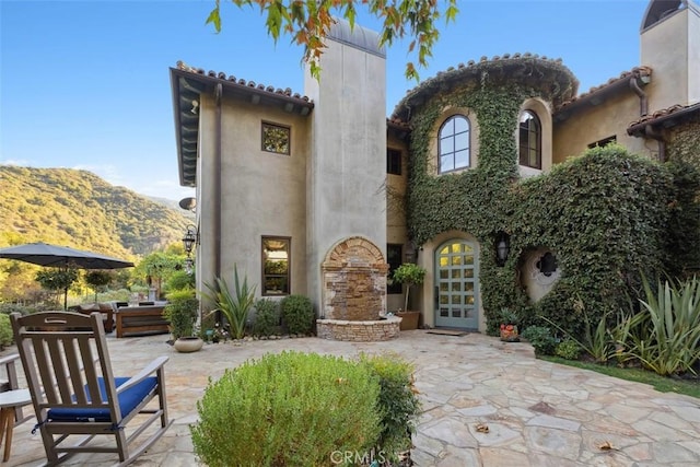 rear view of house featuring a patio area and a mountain view