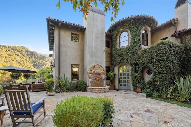 back of house with a mountain view, a patio area, and french doors