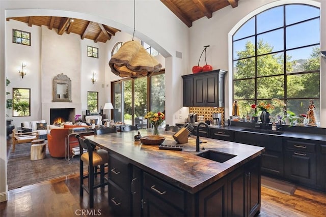 kitchen featuring sink, high vaulted ceiling, wood ceiling, and beamed ceiling